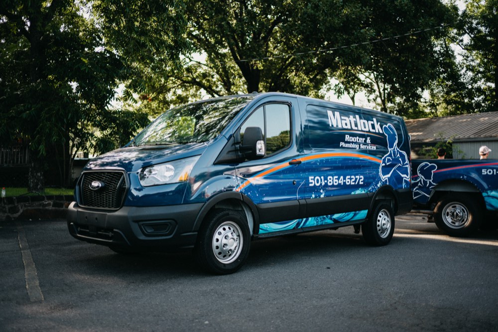 Wrapped Matlock service van parked under trees