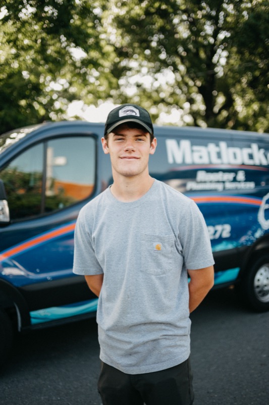 Matlock crew member in cap and casual shirt by the van
